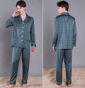 Detail of silk pajama set showing grey-blue grid pattern and contrast gold piping