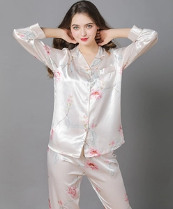 Detail of silk-like champagne pink pajama set with floral prints and button-up front