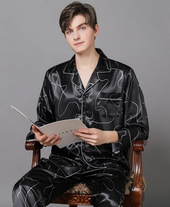 Close-up of premium satin pajama details with white piping and artistic laser line print