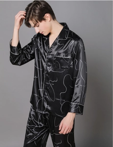 Detail of premium black silk pajamas for men with white abstract prints and piping