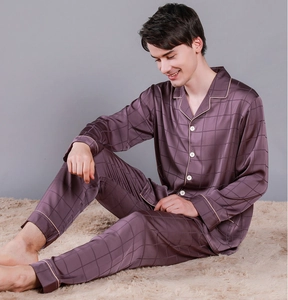 Detail of silk-like satin pajama set for men with checkered texture and white contrast piping