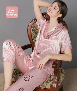 Detail of pink silk pajamas featuring vintage rose and numeral prints on soft fabric