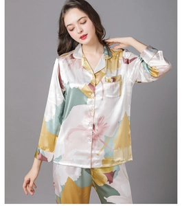 Detailed close-up of floral print silk pajamas featuring a notch collar and button-up front