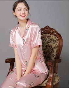 Detail of pink satin floral pajamas with elegant rose prints and luxury silky texture