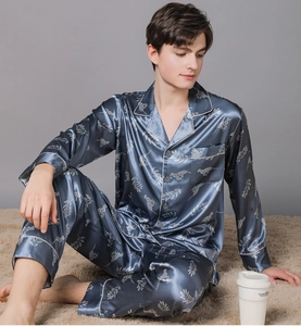 Detail of men's navy blue satin pajama set featuring white leopard and leaf prints