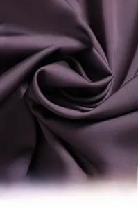 Macro shot of smooth purple silk fabric showing the fine texture of sleepwear material