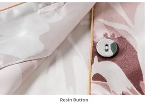 Macro detail of silk pajama set showing pink leaf print and premium resin button