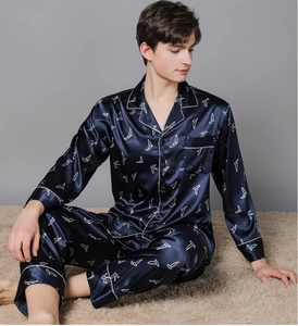 Close-up of deep blue silk satin men's pajamas with white geometric bird patterns