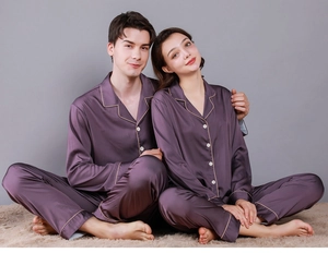 Detailed view of couple in violet silk pajamas with contrast piping and buttoned shirts