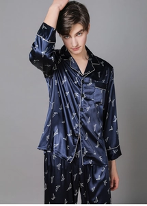 Detail of navy blue silk pajamas with white geometric bird print and white piping accents