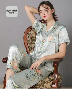 Detail of light green floral silk pajamas featuring tropical print and piping decoration