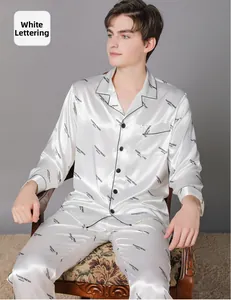 Close-up of white silk pajama suit with black letter print and contrast piping detail