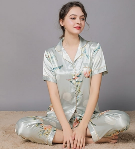Detail of light green floral silk pajamas featuring a short-sleeved button-up top and long pants