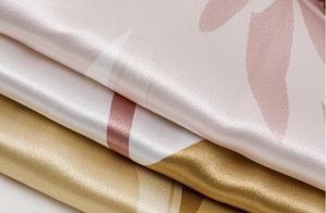 Detail of silk satin fabric showing elegant leaf prints and soft glossy texture