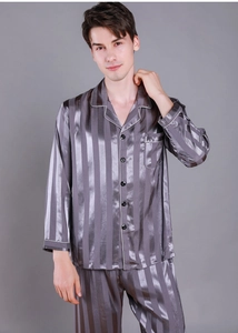 Macro detail of men's silk-like pajama set showing grey vertical stripes and satin texture
