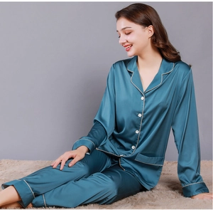 Detail of lake blue silk pajama set for women with elegant golden piping and satin texture