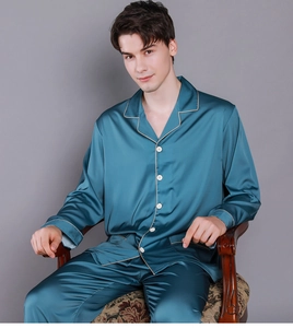 Detail of men's deep peacock blue silk pajamas with gold piping and white buttons