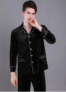 Detailed view of men's black velvet pajamas with diamond texture and white piping details