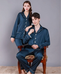 Detail of navy blue silk pajama set featuring white piping and classic button-up collar