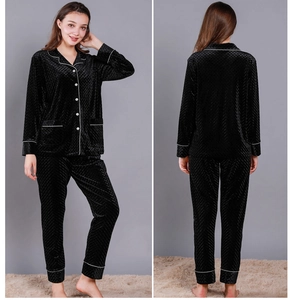 Detail of black velvet pajama set featuring white piping and diamond embossed texture