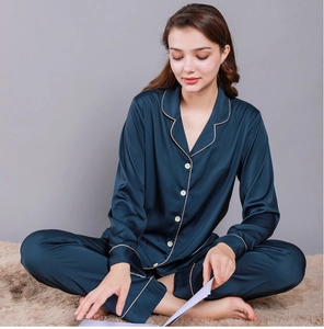 Detail of navy blue silk pajamas for women featuring golden piping and satin finish