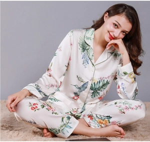 Detailed view of women's silk pajamas featuring elegant floral and hummingbird patterns