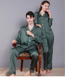 Detail of dark green silk satin pajama set with contrast piping and soft metallic luster