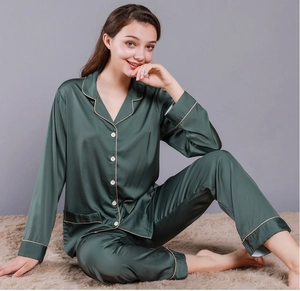 Detail of dark green silk pajamas set with premium white buttons and golden piping trim