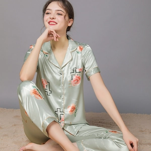 Women's pale green silk satin pajama set featuring floral prints and short sleeves