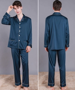 Detail view of navy silk pajama set showing button-down top and contrasting gold piping