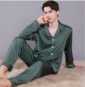 Detailed view of dark green silk satin pajama set with contrast piping and button closure