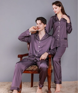 Detail of dark purple satin pajama set with golden piping on cuffs and lapel