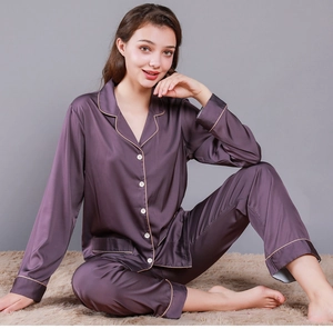Detail of dark purple satin pajamas with contrast piping and white buttons set