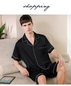 Detail of men's black silk pajamas featuring contrast white piping and a soft satin finish