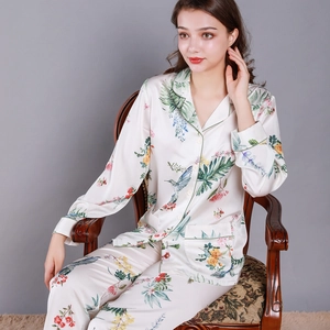 Women's silk satin pajama set with floral and hummingbird prints in apricot color
