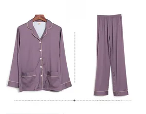 Detail of silk-like dark purple pajama set with long sleeves and contrast piping trim