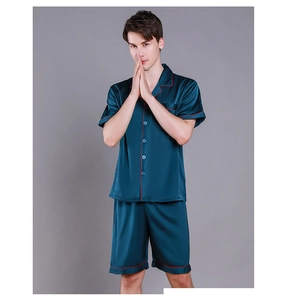 Detail view of navy silk pajamas with red piping trim and smooth satin texture for men