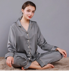 Detail view of gray satin pajama set with long sleeves, notched collar, and contrast piping