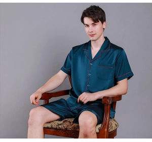 Close-up of men's dark blue silk pajamas with stylish red piping and button details