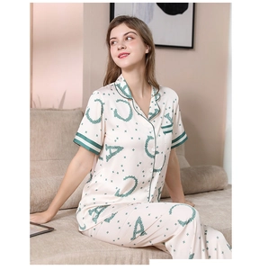 Detail of premium silk pajamas with abstract green print and luxury contrast piping