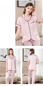Detailansicht des rosa Seidenpyjamas mit schwarzen Spitzenborten an Kragen und Tasche