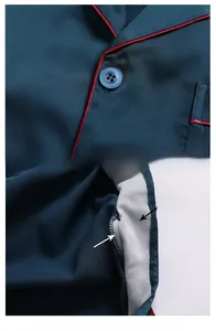 Detail of silk pajamas featuring contrast red piping, premium buttons and lining
