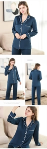 Detail of navy silk pajamas featuring white lace trim on the collar and sleeve cuffs
