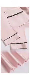 Close-up of pink satin pajama fabric with black lace trim and smooth silk texture