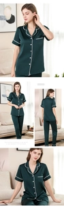 Details von dunkelgrünen Seidenpyjamas mit edler weißer Spitze und Perlenknöpfen