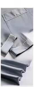 Détails du pyjama en soie grise montrant la bordure de poche, poignets et texture satin