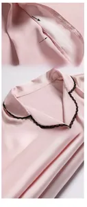 Detail von rosa Seidenpyjama-Revers mit schwarzer Spitze und feiner Nähtechnik
