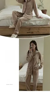 Detail of beige fleece pajama set featuring soft flannel texture and black piping trim