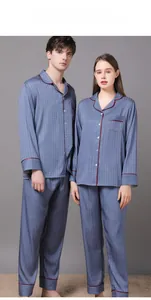 Detail view of grey-blue silk pajamas with houndstooth pattern and red piping design