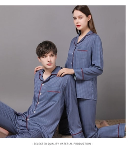 Detail of silk satin pajamas with red contrast piping and dark plaid texture